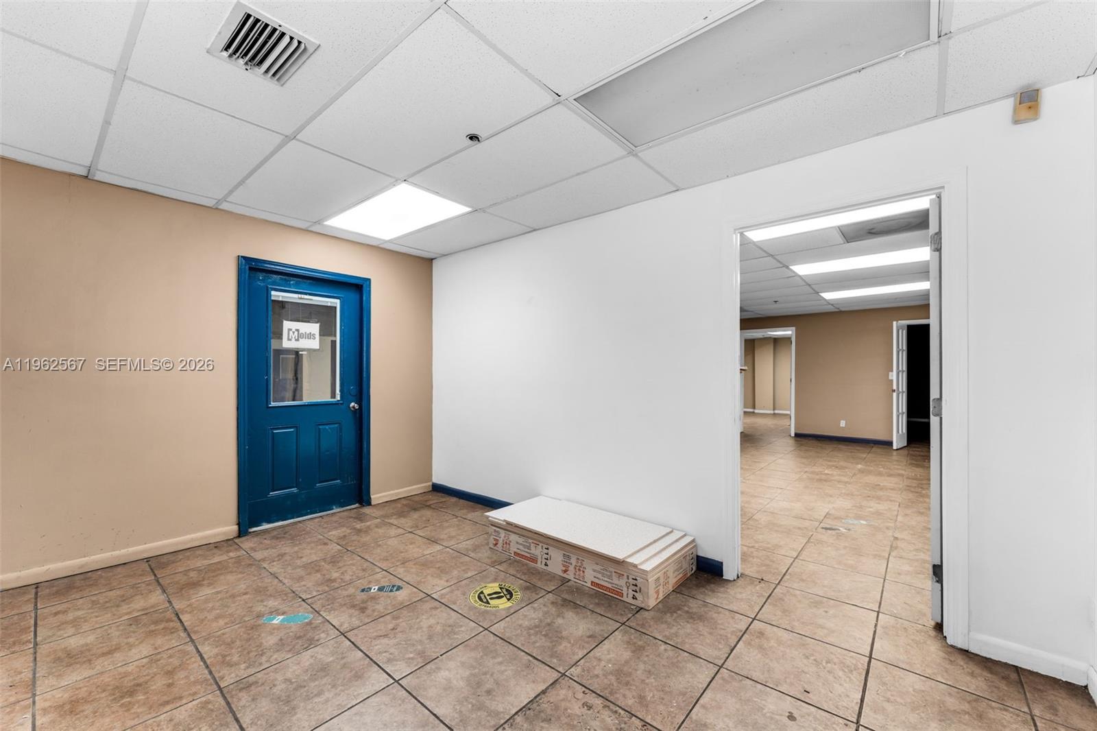 An interior office space features tiled flooring, a blue door, and a white wall — 7620 W 2nd Ct, Hialeah FL 33014, HIALEAH, FL