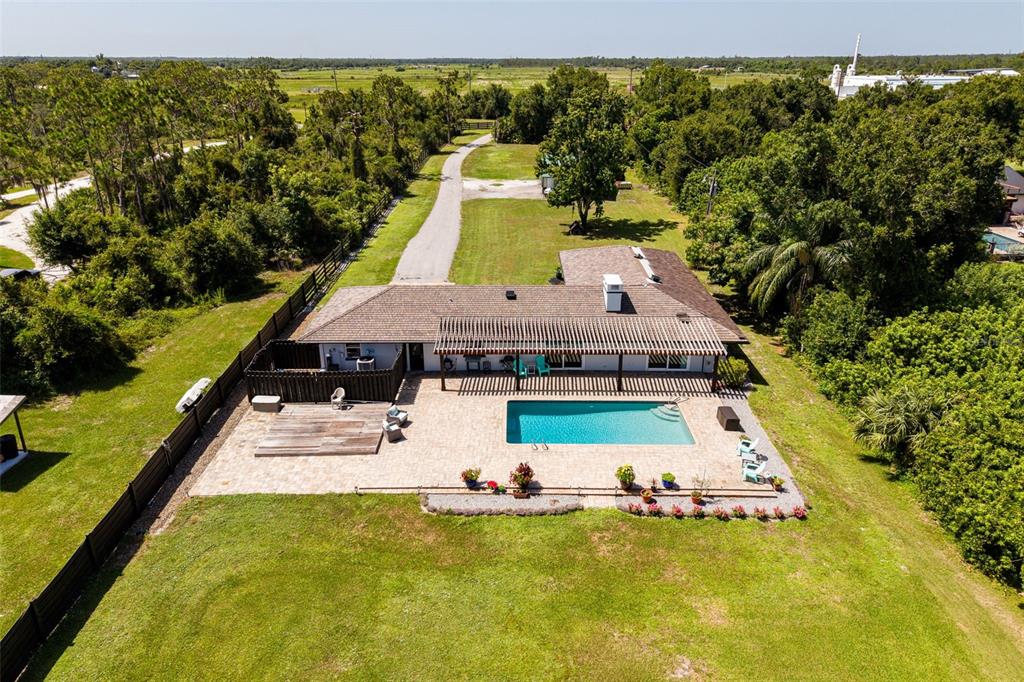 An aerial view of a single-story house with a swimming pool and a wooden deck — 37951 WASHINGTON LOOP ROAD, PUNTA GORDA, FL