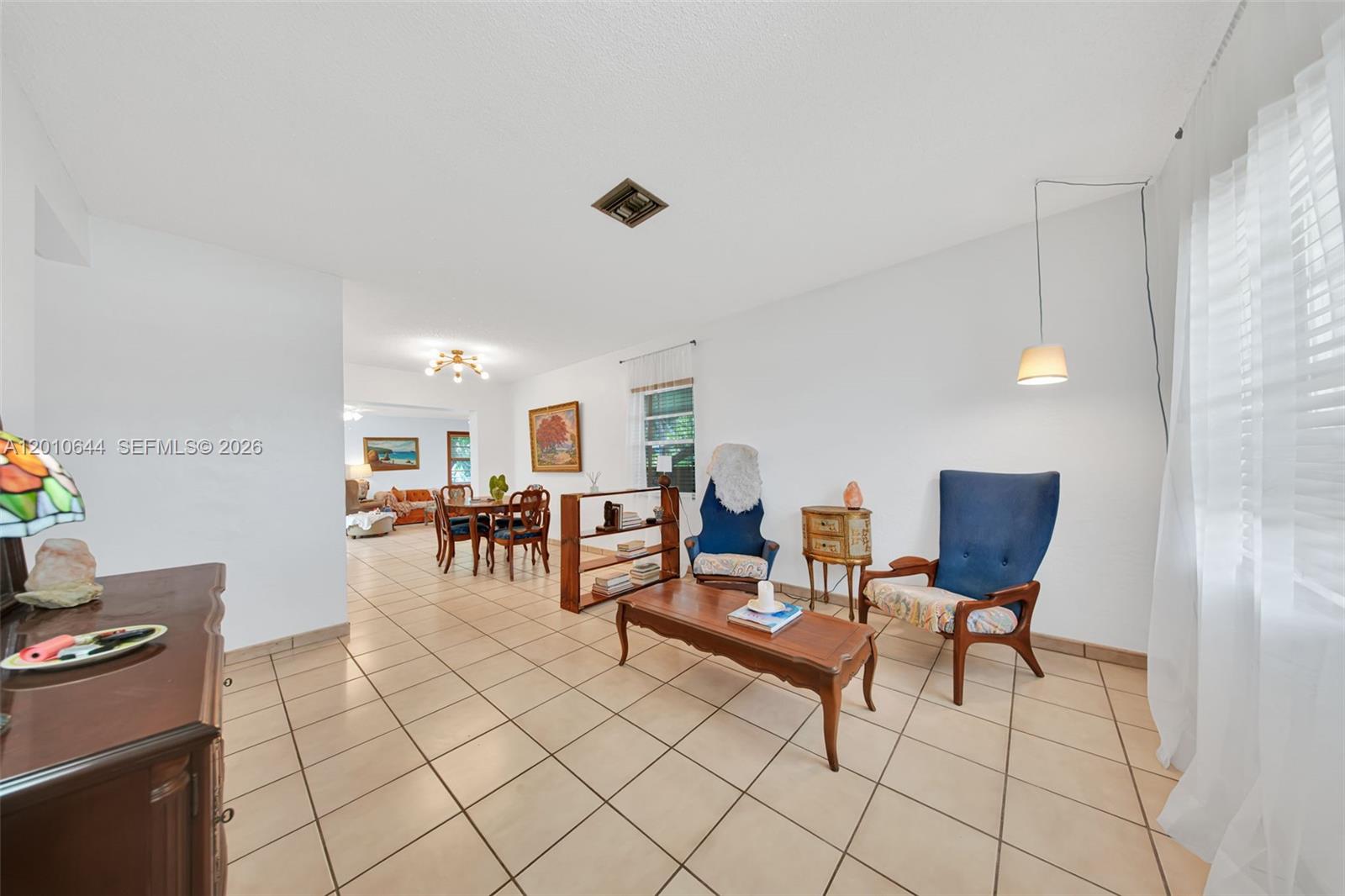 A living room with tile floors features two blue armchairs and a wooden coffee table — 7250 SW 34th St Rd, Miami FL 33155, MIAMI, FL