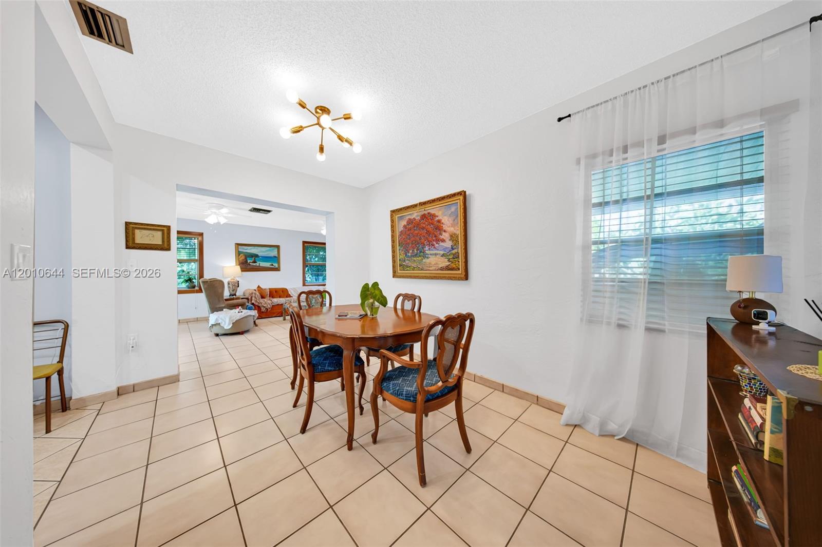 A dining room features tile floors, a wooden table with chairs, and a light fixture — 7250 SW 34th St Rd, Miami FL 33155, MIAMI, FL