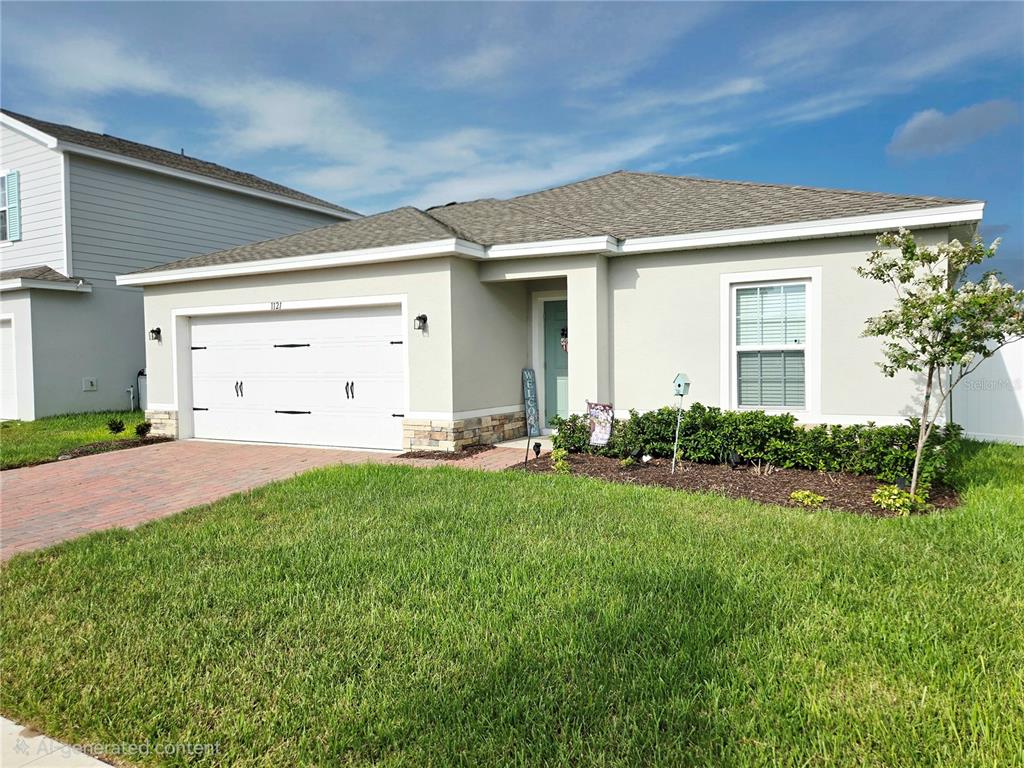 A single-story house with a two-car garage, light stucco exterior, and a brick paver driveway — 1121 LEXINGTON LANE, HAINES CITY, FL