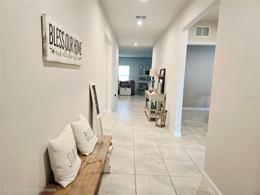 A hallway with light tile flooring, a wooden bench, and a console table — 1121 LEXINGTON LANE, HAINES CITY, FL