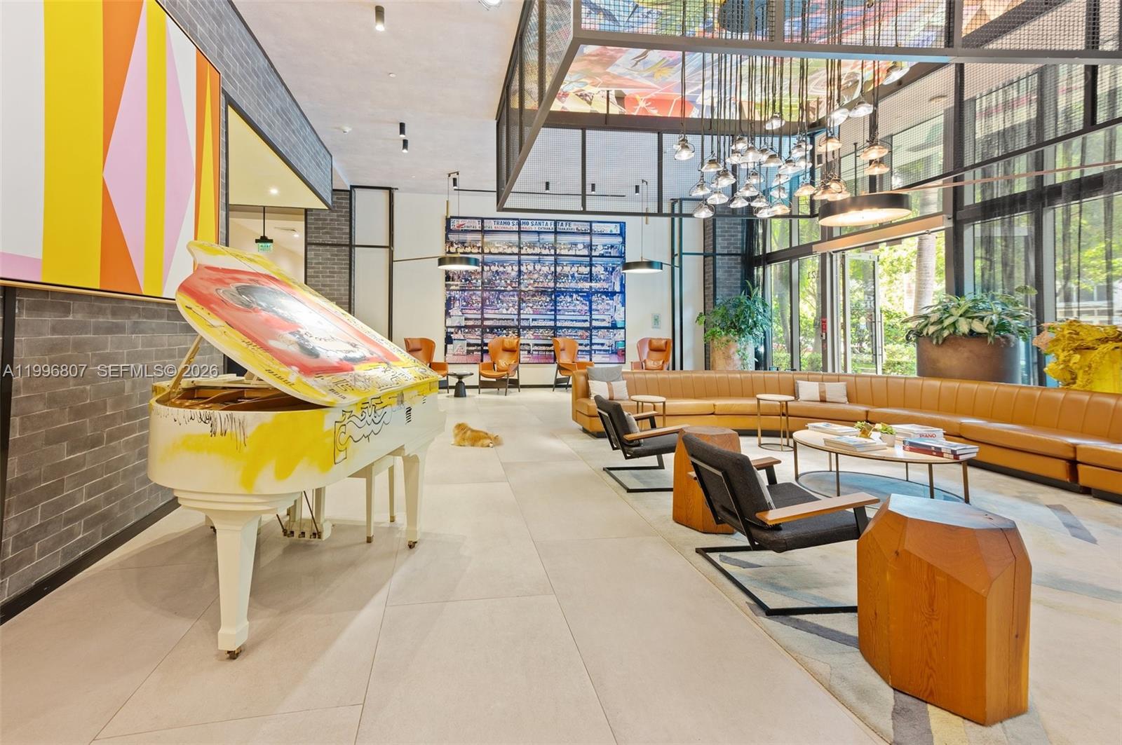 A modern lobby features a painted grand piano, leather seating, and a large wall mural — 121 NE 34th St # 2314, Miami FL 33137, MIAMI, FL