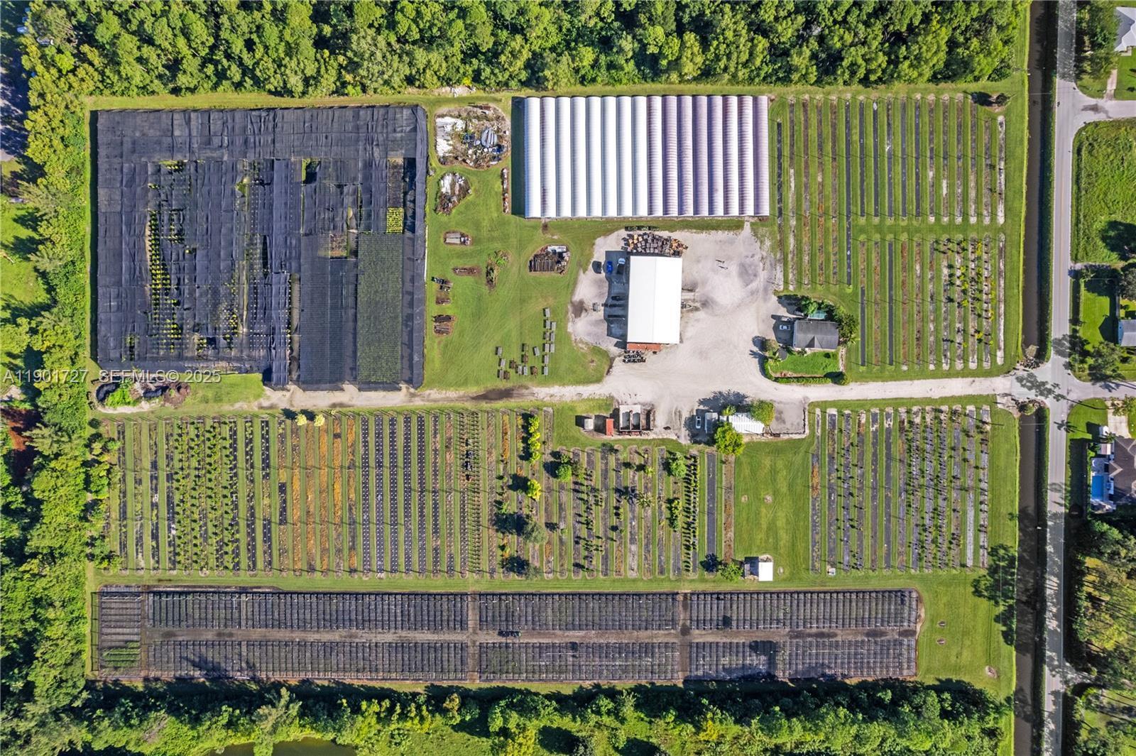 An aerial view shows a large plant nursery with greenhouses, shade structures, and field rows — 1535 B Road, FL 33470, FL