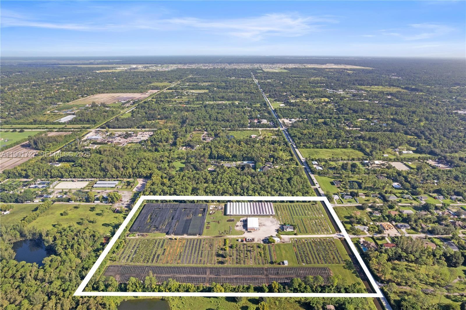 An aerial view shows a large agricultural property with greenhouses, shade structures, and crop rows — 1535 B Road, FL 33470, FL