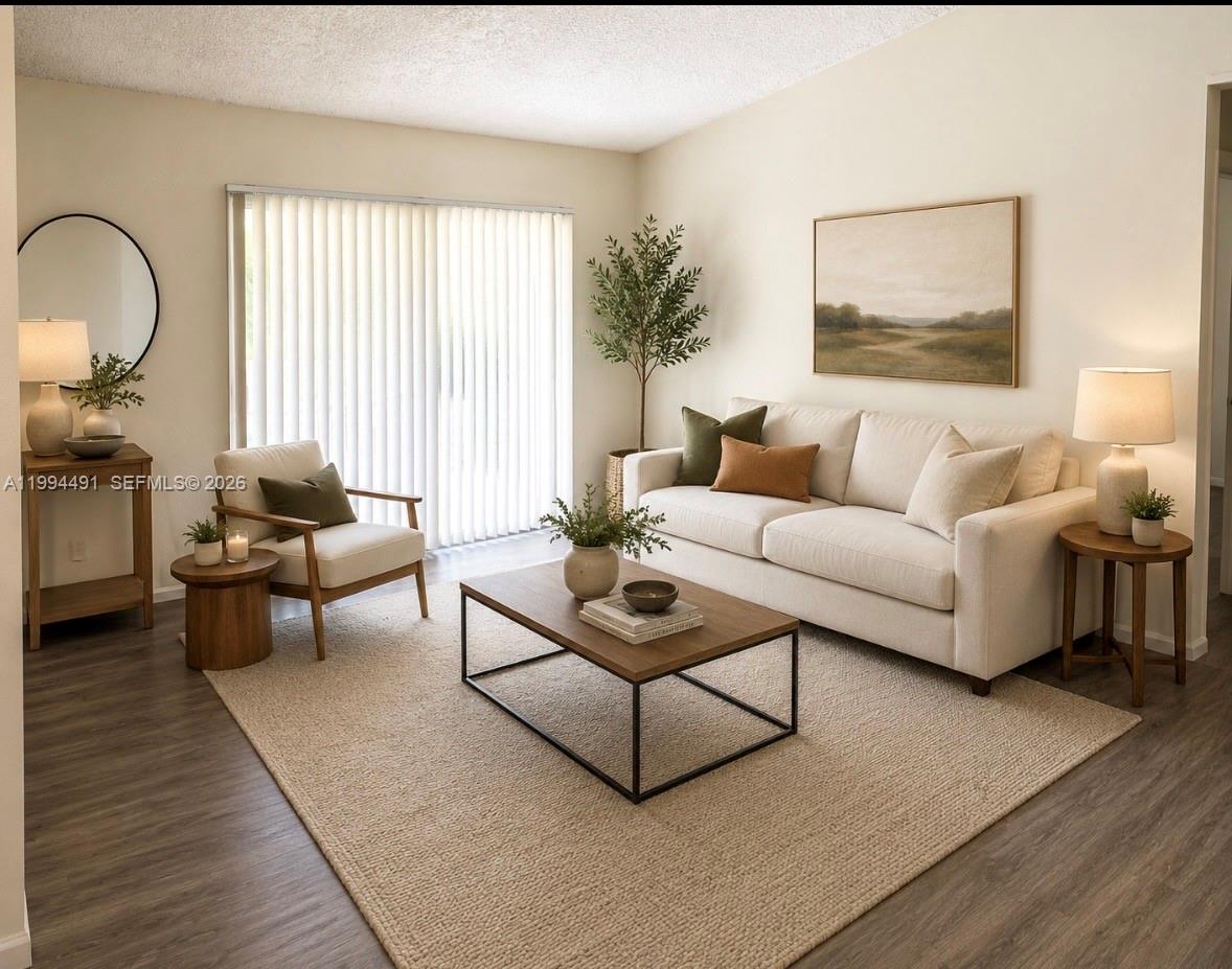 A living room with a beige sofa, wooden coffee table, armchair, and neutral area rug — 10521 SW 158th Ct # 303, Miami FL 33196, MIAMI, FL