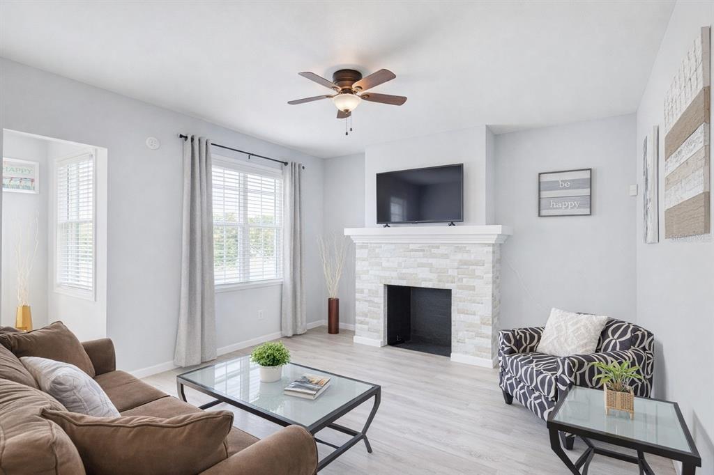 A living room features a stone fireplace, a ceiling fan, and a brown sofa — 501 S MAGNOLIA AVENUE UNIT 3, TAMPA, FL