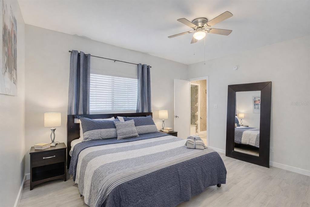A bedroom features a bed with blue striped bedding, a ceiling fan, and a mirror — 501 S MAGNOLIA AVENUE UNIT 3, TAMPA, FL