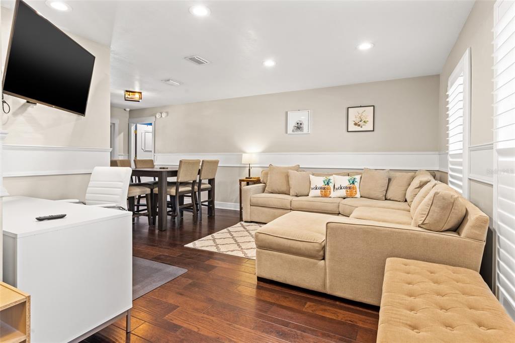 A living room with a sectional sofa, dining area, and a white desk — 6701 LEEWARD ISLE WAY, TAMPA, FL