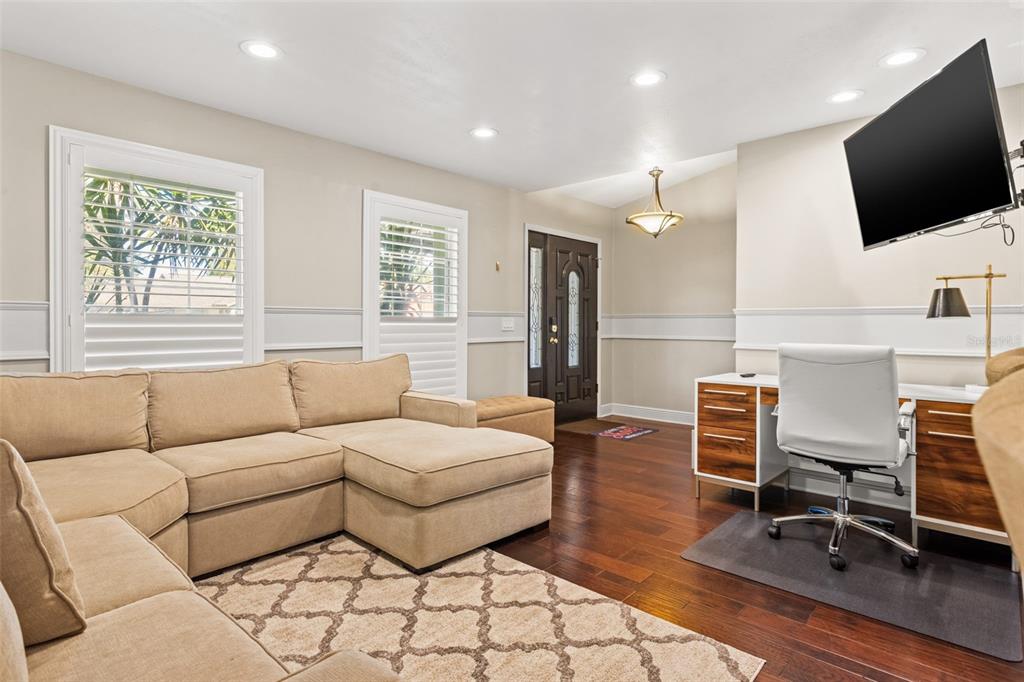 A living room with a tan sectional sofa, a desk, and a front door — 6701 LEEWARD ISLE WAY, TAMPA, FL
