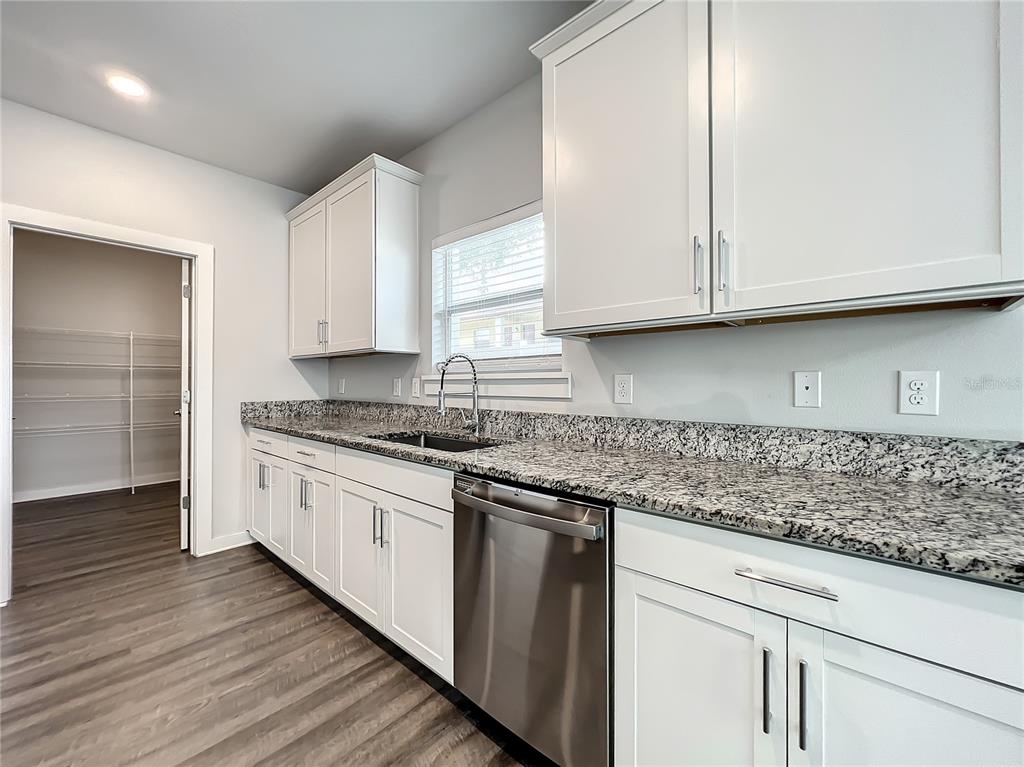 A kitchen features white cabinets, granite countertops, stainless steel appliances, and a walk-in pantry — 3715 W WISCONSIN AVENUE UNIT 3, TAMPA, FL