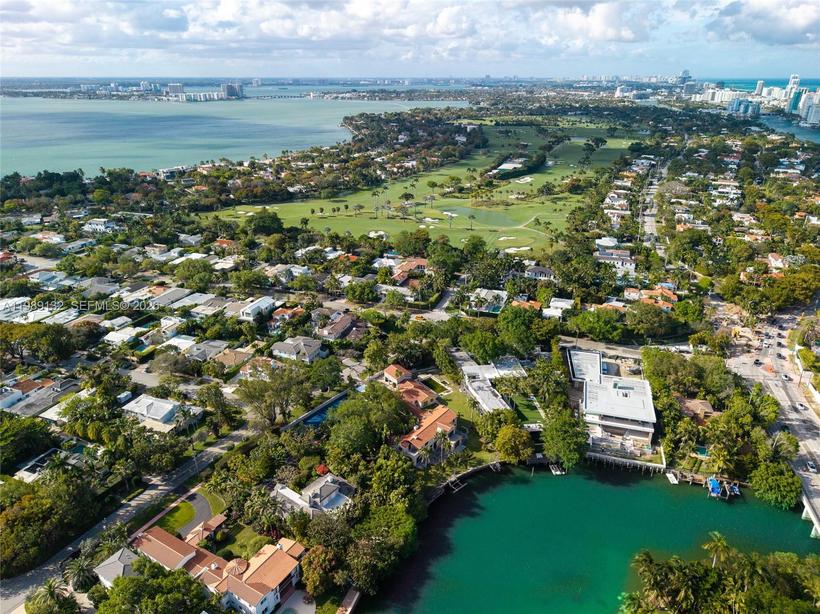 An aerial view shows waterfront homes, a golf course, and a bay in Miami — 5005 Lakeview Dr, Miami Beach FL 33140, MIAMI BEACH, FL