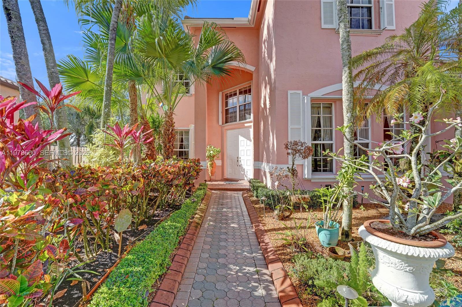 A paved walkway leads to the white front door of a two-story pink house — 14686 SW 35th Ct, Miramar FL 33027, MIRAMAR, FL