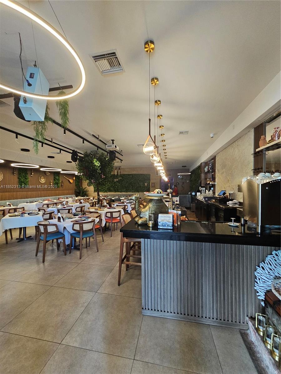 A restaurant interior features a bar, dining tables with white tablecloths, and pendant lighting — 2995 NE 163rd St, North Miami Beach FL 33160, NORTH MIAMI BEACH, FL