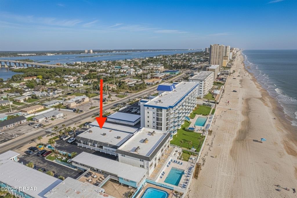 An aerial view shows a beachfront hotel complex with multiple buildings, pools, and parking areas — 3615 S ATLANTIC AVENUE UNIT 211, DAYTONA BEACH, FL