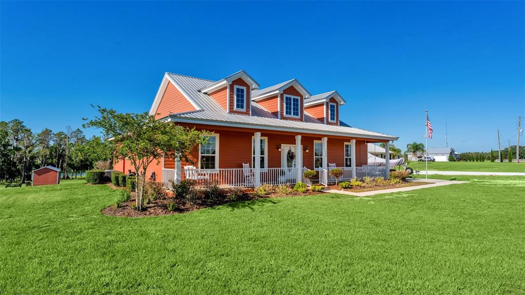 A one-story orange house with a metal roof and three dormers sits on a lawn — 1044 TIMBERS DRIVE, FORT MEADE, FL