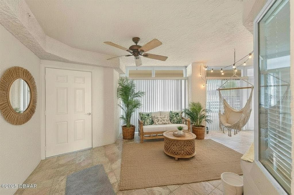 A sunroom features tile flooring, a rattan sofa, a hanging chair, and a ceiling fan — 4575 S ATLANTIC AVENUE UNIT 6209, PONCE INLET, FL