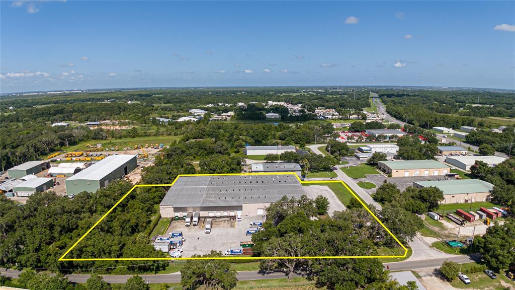 An aerial view shows a warehouse building outlined in yellow with a paved loading area — 3601 PARKWAY BOULEVARD, LEESBURG, FL