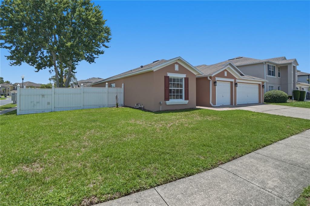 A tan single-story house with a white fence and a two-car garage — 969 HORSESHOE FALLS DRIVE, ORLANDO, FL