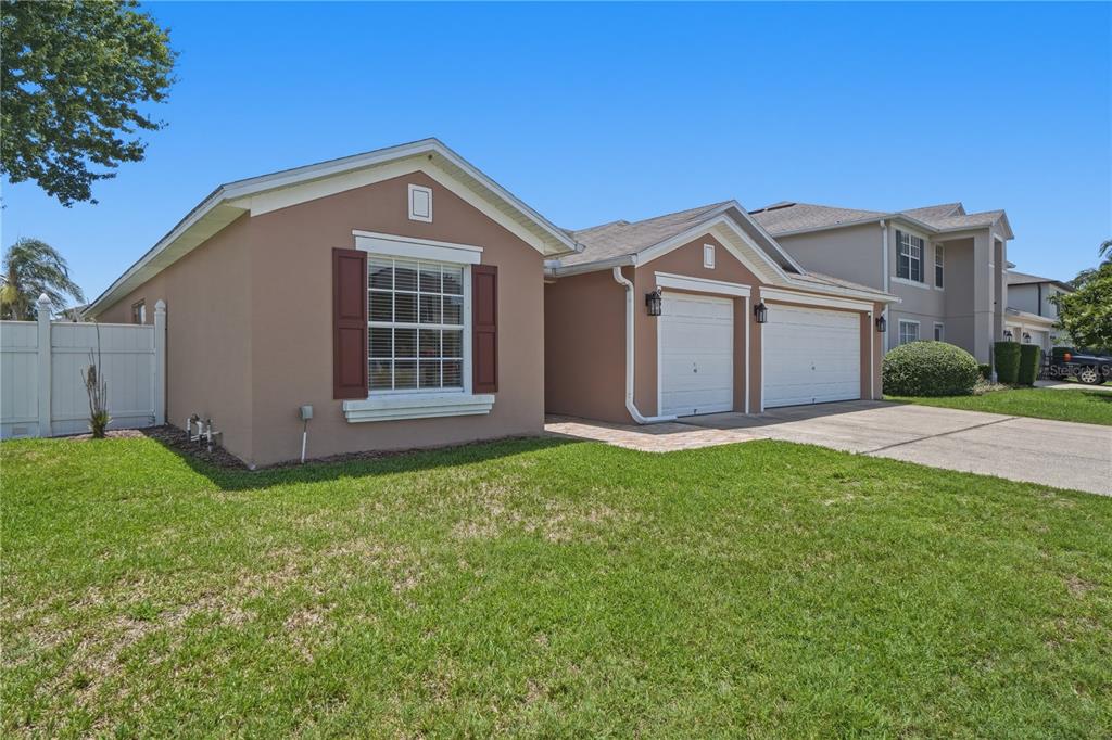 A tan single-story house with a two-car garage and a white vinyl fence — 969 HORSESHOE FALLS DRIVE, ORLANDO, FL