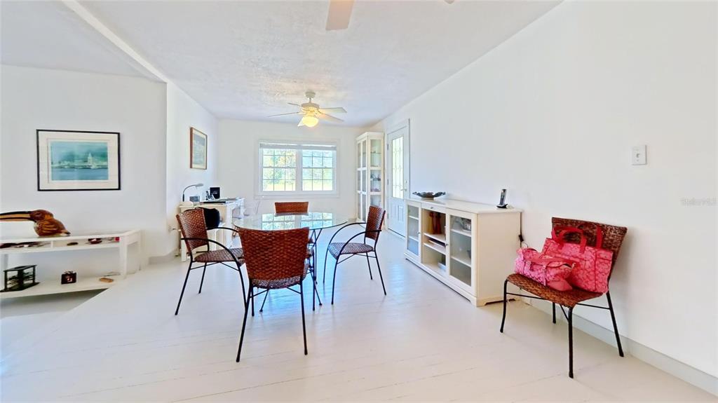 A dining area features a glass-topped table, wicker chairs, white walls, and light-colored flooring — 7390 180TH STREET, MC ALPIN, FL