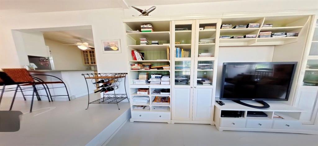 A living room features a large white entertainment center with bookshelves and a flat-screen television — 7390 180TH STREET, MC ALPIN, FL