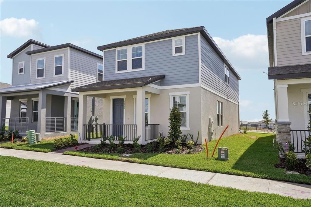 A two-story house with blue siding, a covered front porch, and a green lawn — 16484 SILVER BROOK WAY, WINTER GARDEN, FL