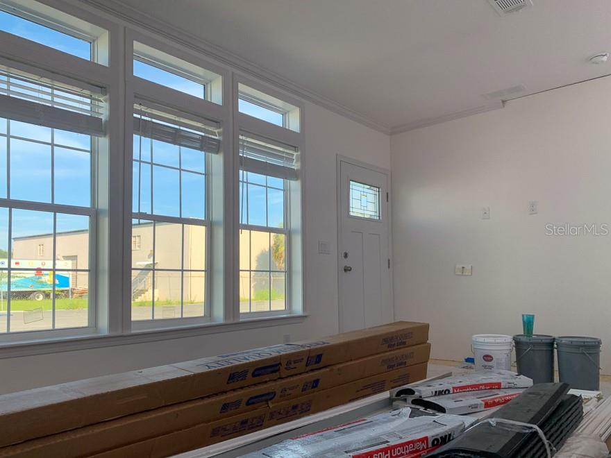 An interior room features large windows, a white door, and construction materials on the floor — 71 TWIN SHORES BOULEVARD, LONGBOAT KEY, FL