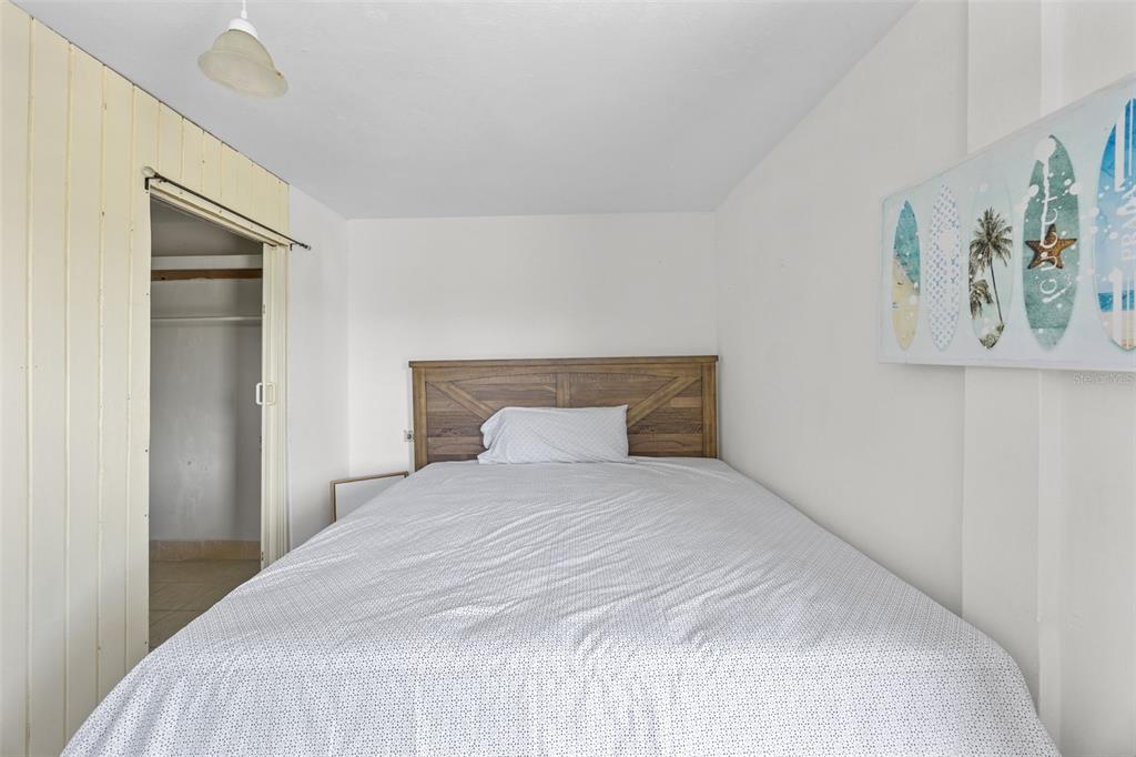 A bedroom features a bed with a wooden headboard, a closet, and wall art — 303 Calle El Salto EL SALTO, ANASCO, PR