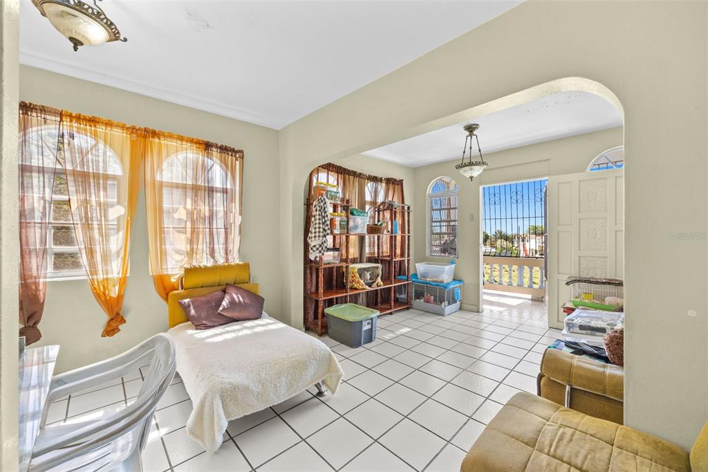 A living area with white tile floors, arched transitions, and a doorway leading to a balcony — 303 Calle El Salto EL SALTO, ANASCO, PR