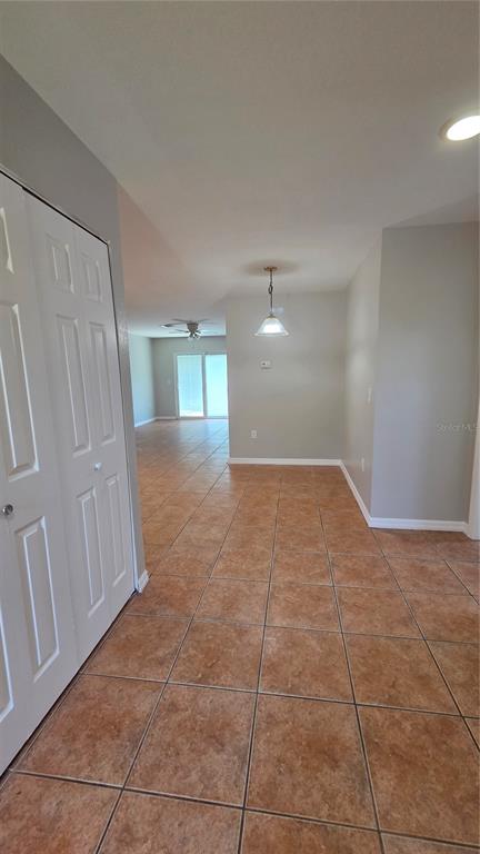 A room with tan tile flooring, a white closet door, and a hanging pendant light — 1210 FAIRWAY DRIVE, LAKELAND, FL