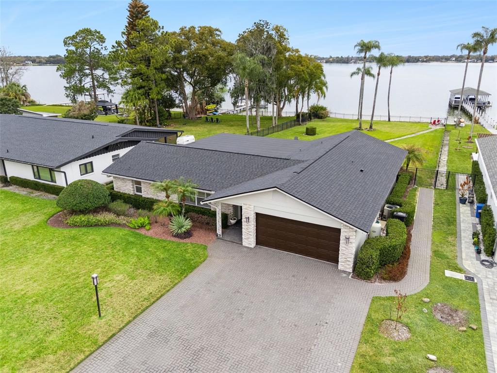 An aerial view shows a single-story house with a dark roof and a paved driveway — 6007 LINNEAL BEACH DRIVE, APOPKA, FL