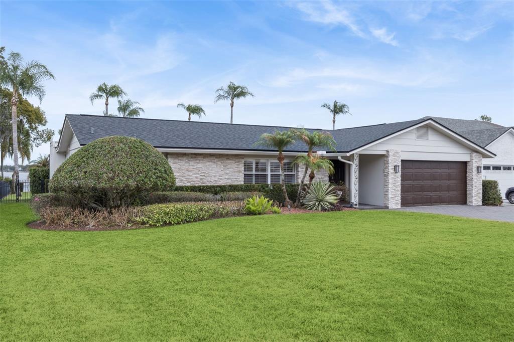 A single-story house with a stone facade, dark roof, and a two-car garage — 6007 LINNEAL BEACH DRIVE, APOPKA, FL