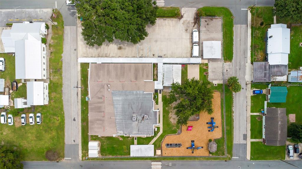 An aerial view shows a building with a playground, parking lot, and surrounding residential streets — 258 SW COLUMBIA AVENUE, LAKE CITY, FL