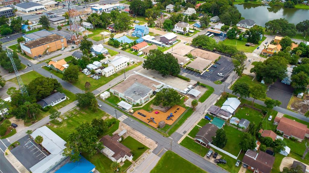 An aerial view shows a neighborhood with houses, a playground, and commercial buildings — 258 SW COLUMBIA AVENUE, LAKE CITY, FL