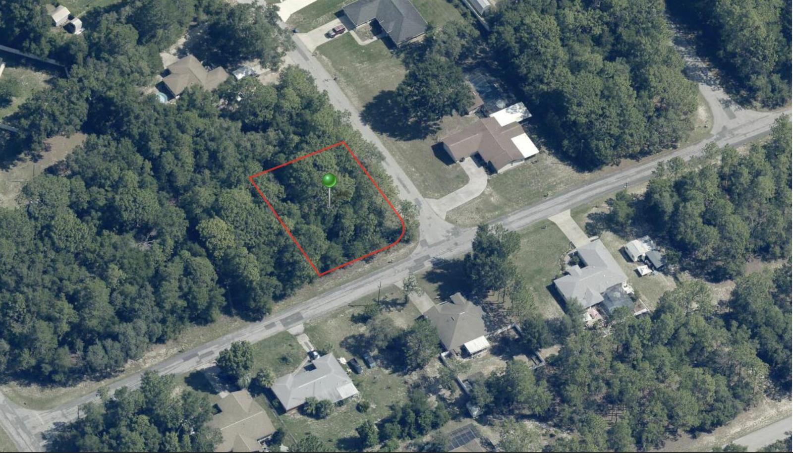 An aerial view shows a wooded, rectangular vacant lot outlined in red on a street — 1021 W Almont Place, FL 34434, FL
