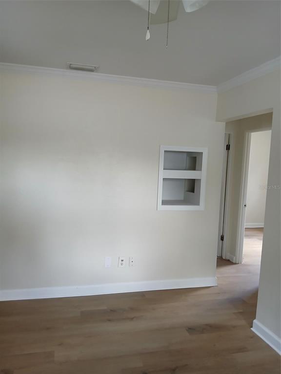 A kitchen features white cabinets, a white stove, a double sink, and light wood flooring — 2834 25TH AVENUE N, ST PETERSBURG, FL
