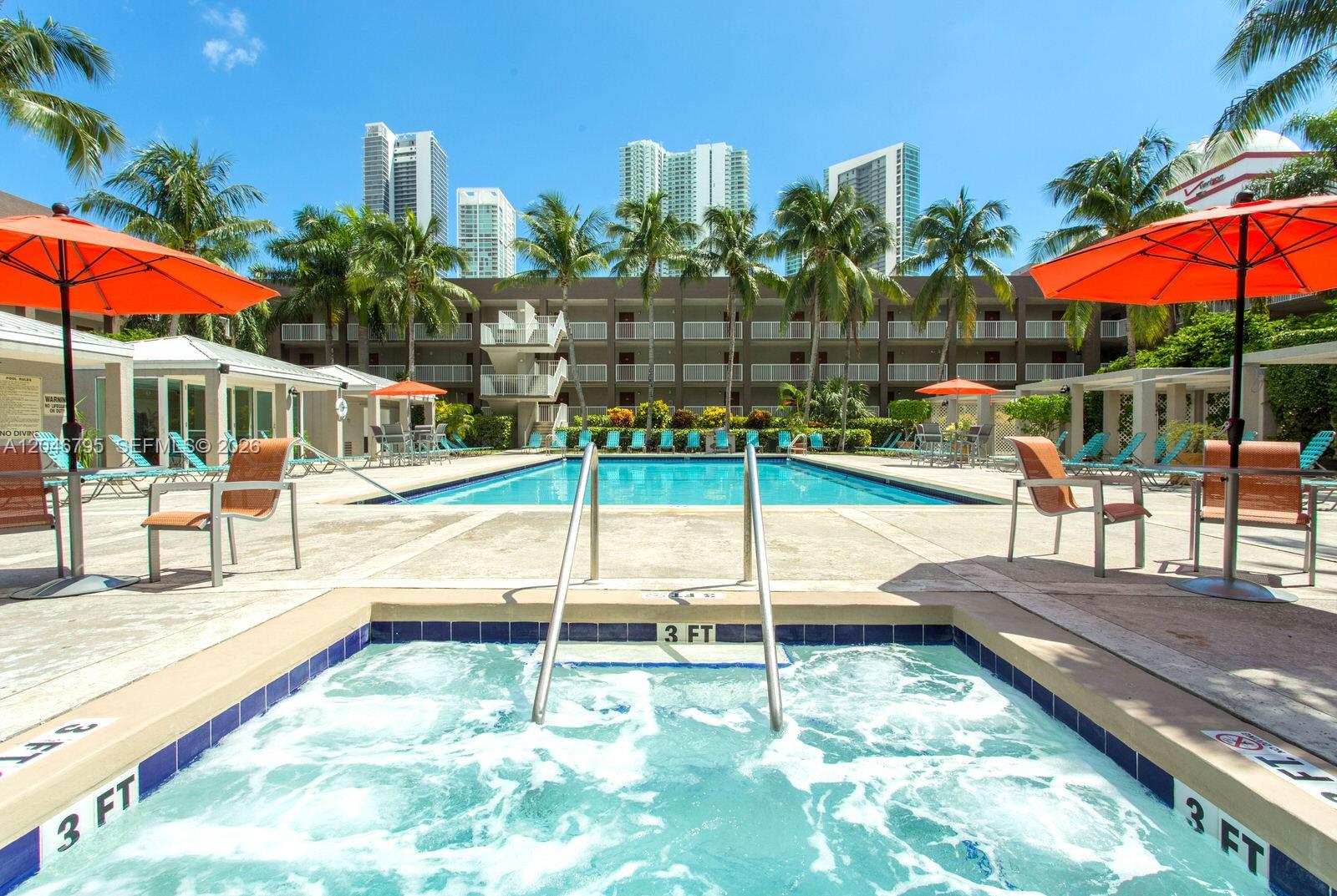 A swimming pool and hot tub are surrounded by lounge chairs and palm trees — 915 NW 1st Ave, Miami FL 33136, MIAMI, FL
