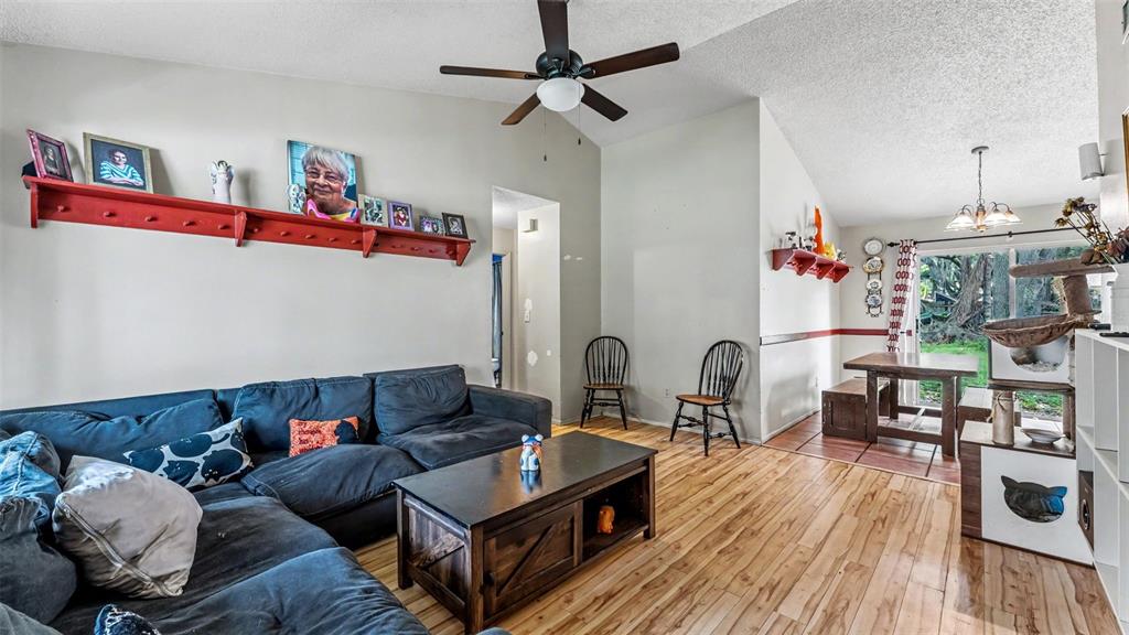 A living room with a dark sectional sofa, wood coffee table, and wood-look flooring — 2110 JOHNSON LOOP, PLANT CITY, FL