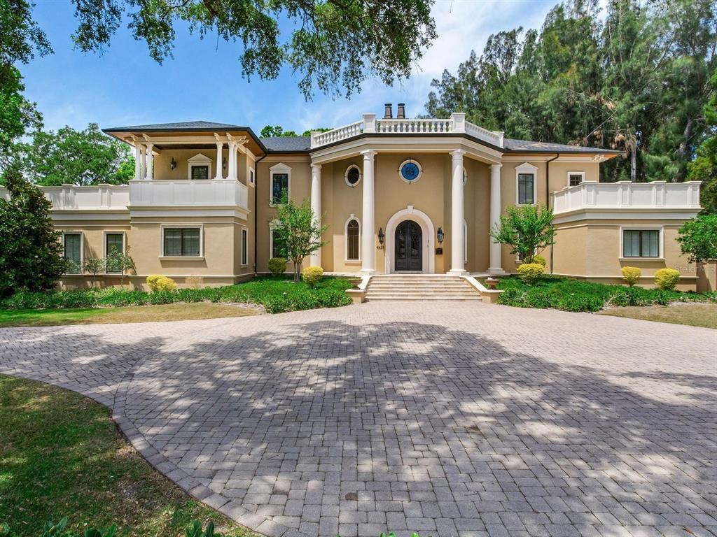 A large, two-story tan house features a grand columned entrance and a paved circular driveway — 4623 W SAN JOSE STREET, TAMPA, FL