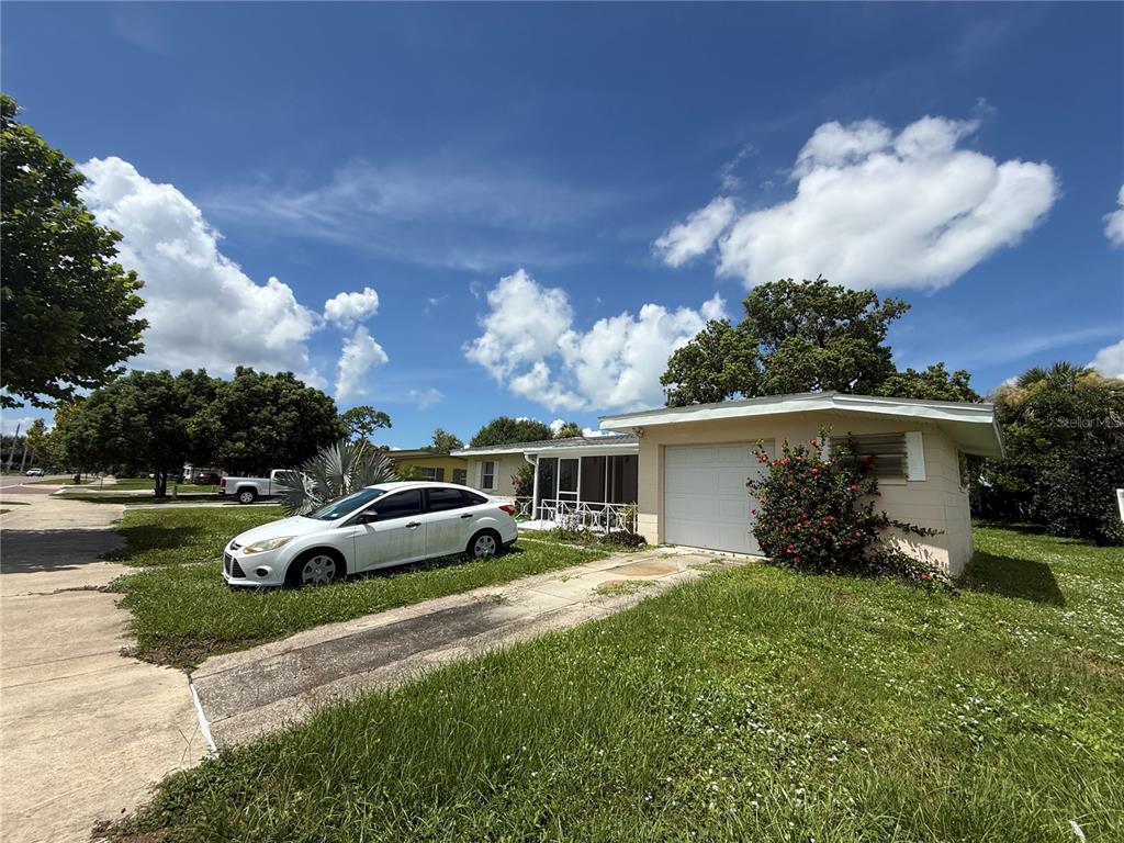 A single-story house with a white car parked on the lawn and a concrete driveway — 2353 ELKCAM BOULEVARD, PORT CHARLOTTE, FL