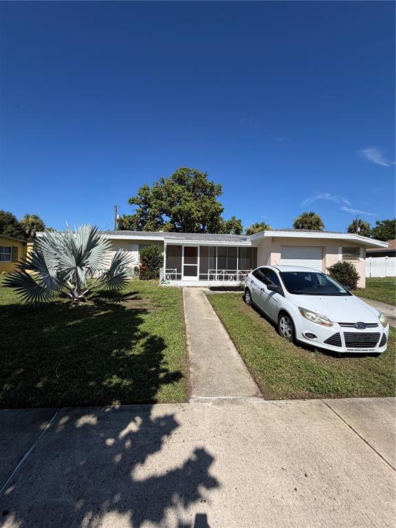 A single-story house with a white exterior, a front porch, and a car parked outside — 2353 ELKCAM BOULEVARD, PORT CHARLOTTE, FL