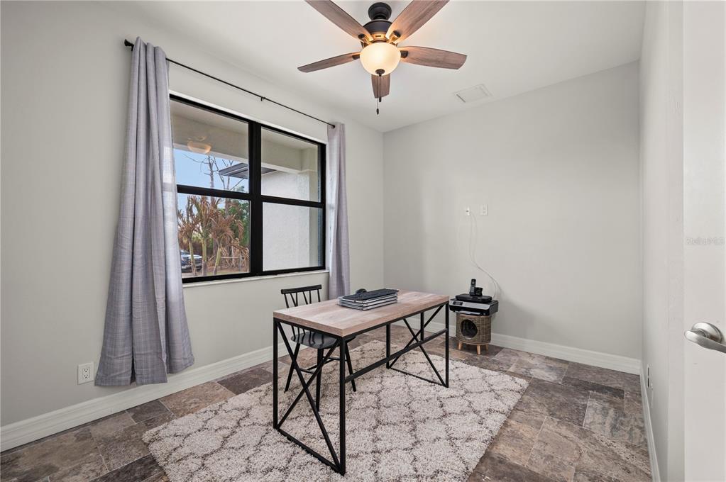 A home office features a desk, a ceiling fan, a window with curtains, and tile flooring — 4301 SOUTH ROAD, NORTH FORT MYERS, FL