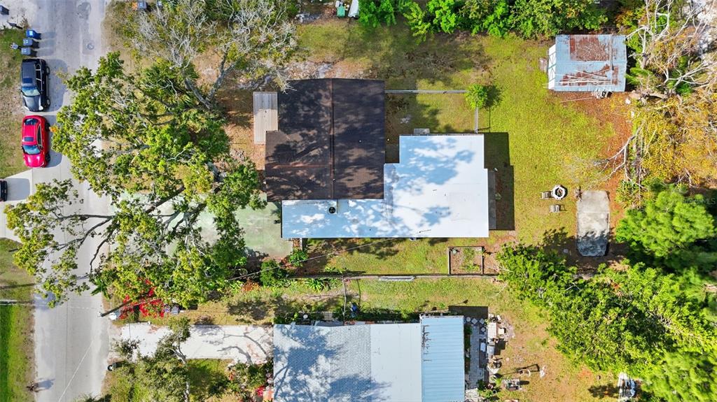 An aerial view shows a house with a two-tone roof, surrounding trees, and a driveway — 1619 SUPONIC AVENUE, SARASOTA, FL