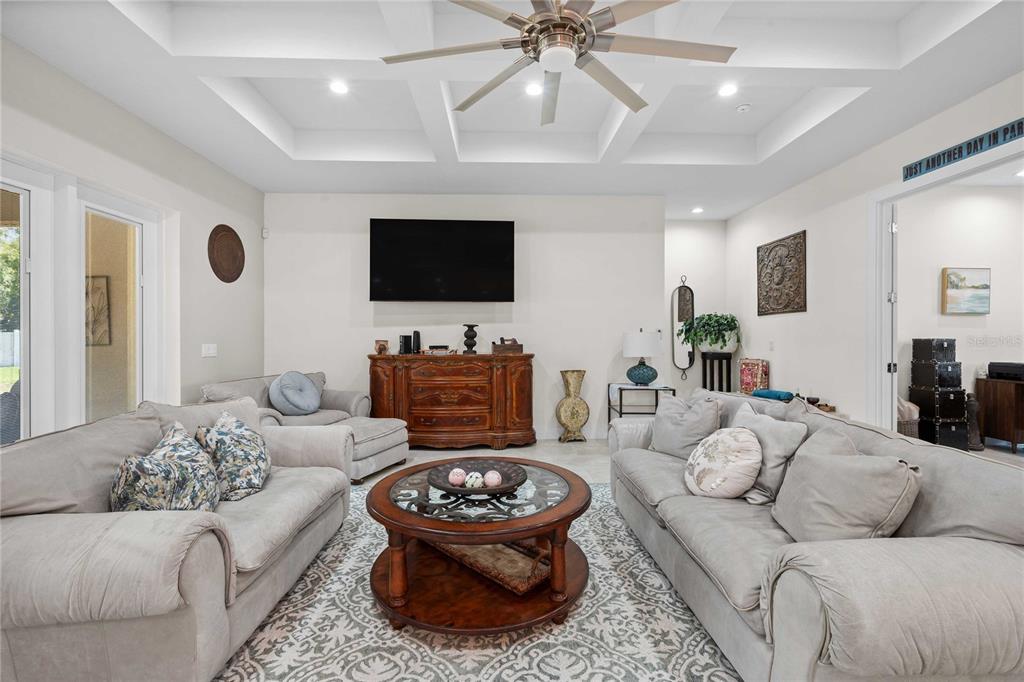 A living room features a coffered ceiling, a ceiling fan, and two light-colored sofas — 17601 HANNA ROAD, LUTZ, FL