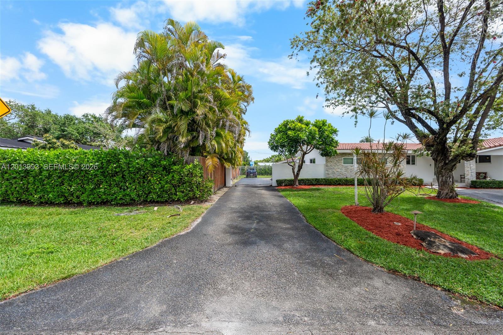 A paved driveway leads toward a gated entrance between a hedge and a grassy yard — 12425 SW 91st Ave, Miami FL 33176, MIAMI, FL