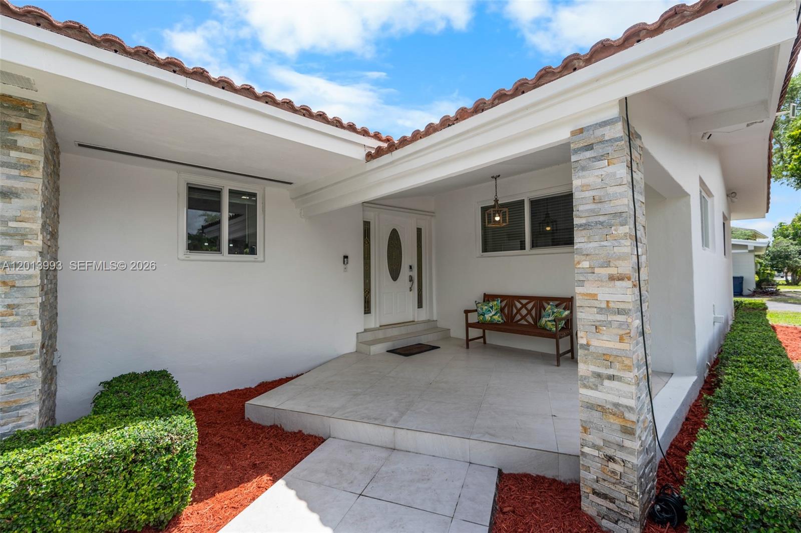 The exterior entrance features a tiled porch, stone-accented columns, and a white front door — 12425 SW 91st Ave, Miami FL 33176, MIAMI, FL