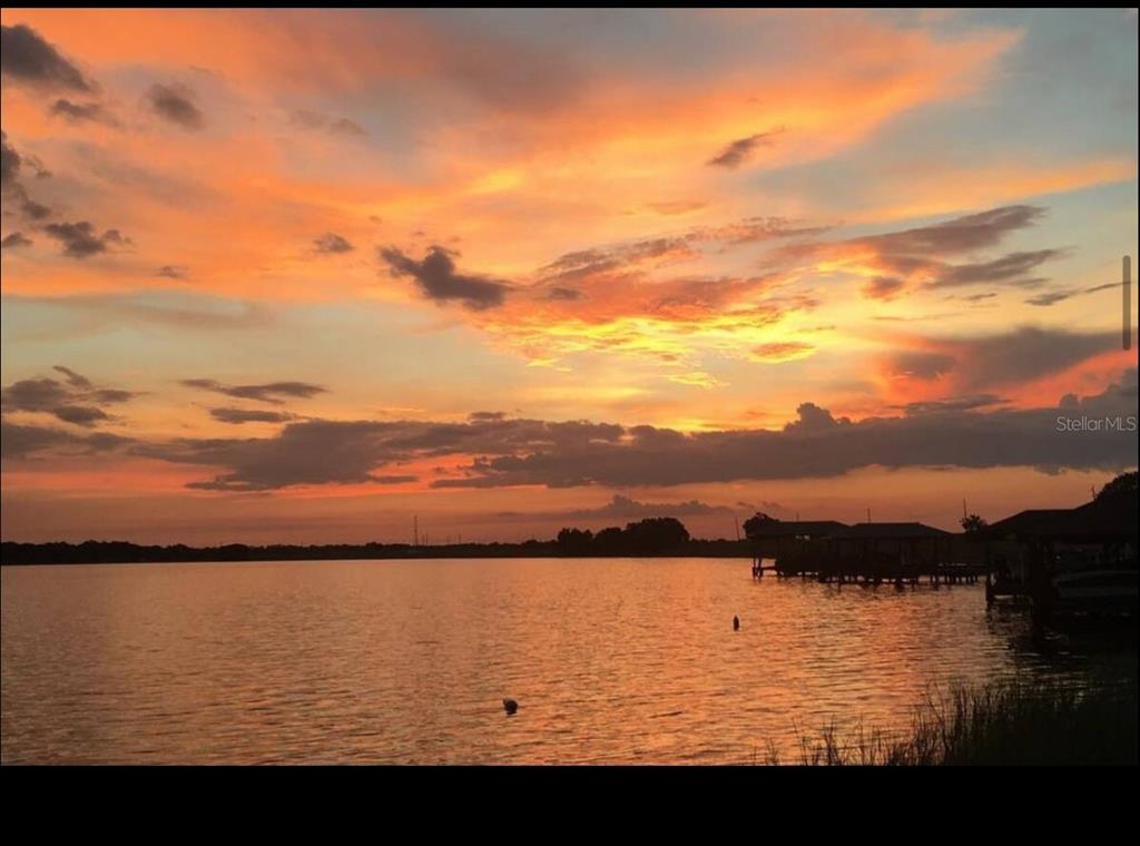 A vibrant sunset glows over a calm lake with boat docks visible on the right — 514 HILLSIDE DRIVE, AUBURNDALE, FL