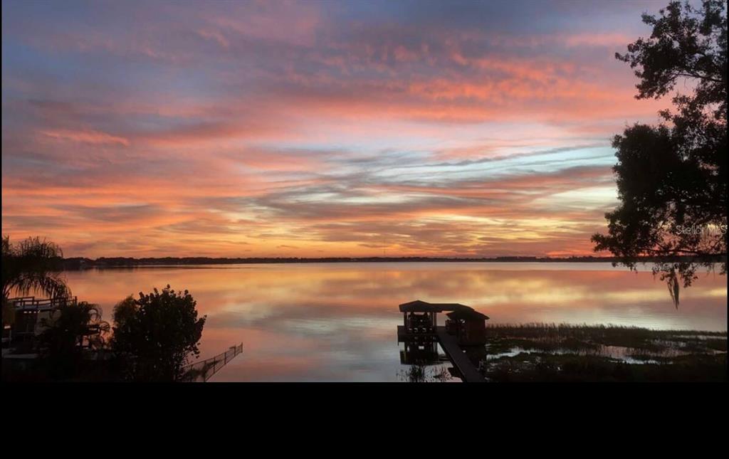 A vibrant sunset reflects over a calm lake with a wooden dock and pier — 514 HILLSIDE DRIVE, AUBURNDALE, FL