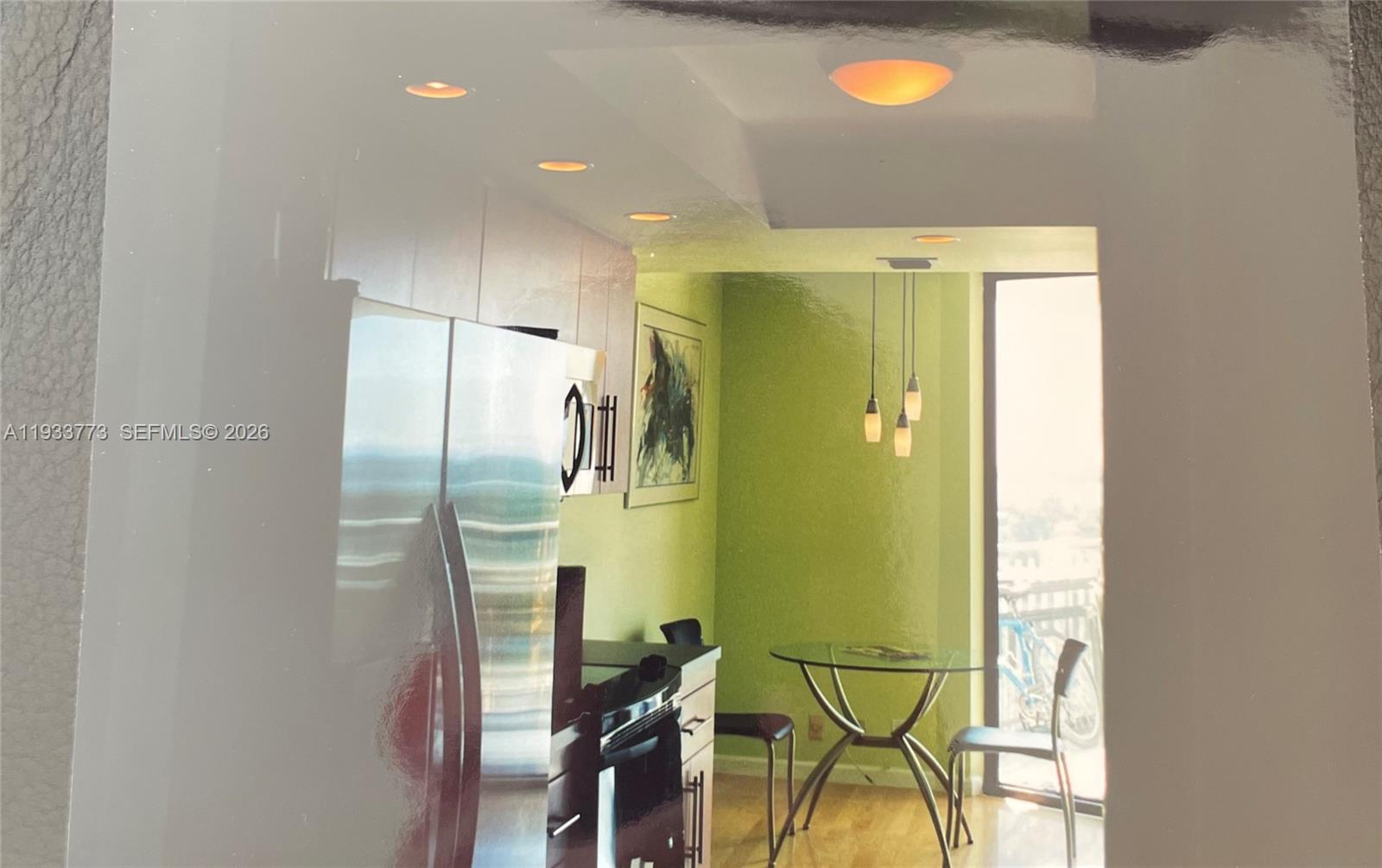 A kitchen with green walls, a glass dining table, and stainless steel appliances — 1000 Quayside Ter # 806, Miami FL 33138, MIAMI, FL